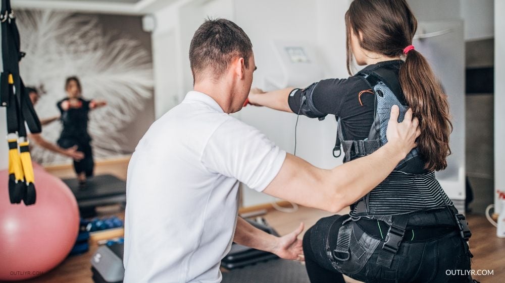 Woman instructed by an EMS trainer