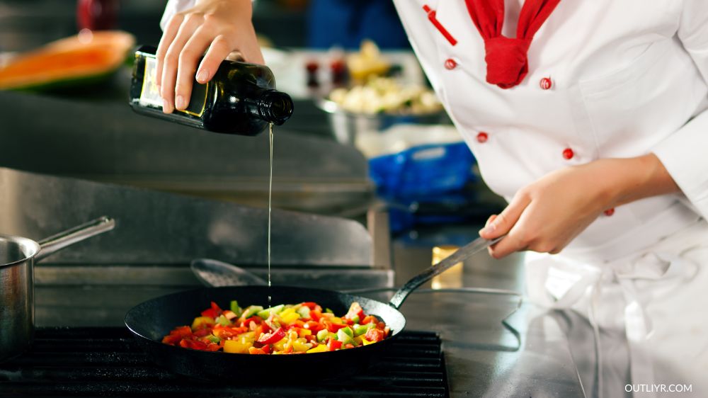 Chef pouring oil while cooking