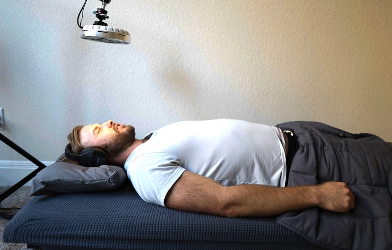 Nick Urban using the Zenthesia vibroacoustic bed during a RoXiva light session