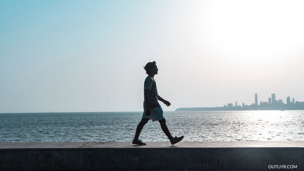A person walking on a boardwalk along the coast